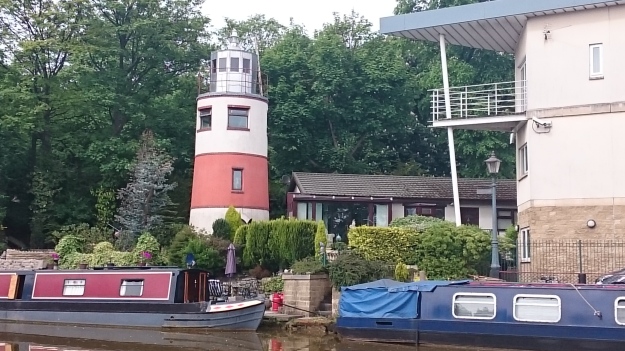 Red and white lighthouse, with two canal barges by the Bridgewater Canal